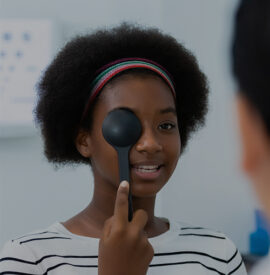 Young woman african american using occluder for eye test ophthalmological in optics clinic. woman checkup eye health with equipment opthalmology medical in hospital.